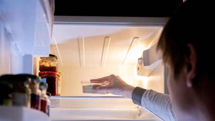 Nuori mies katsoo puolityhjää jääkaappia.