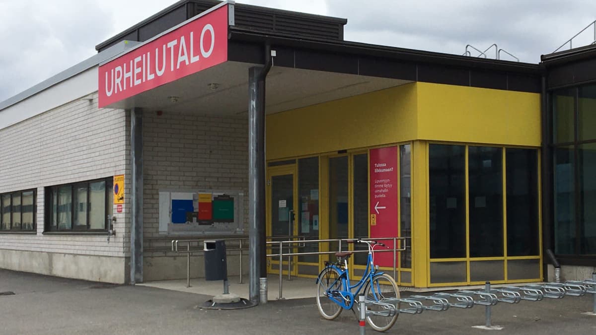 Punainen urheilutalon kyltti sisäänkäynnin yläpuolella.