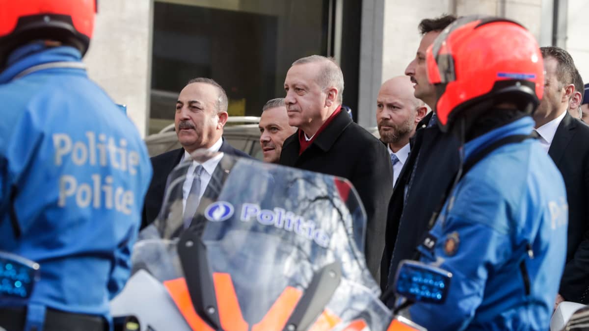 Turkin ulkoministeri ja presidentti kävelevät poliisirivistön ohi Brysselissä.