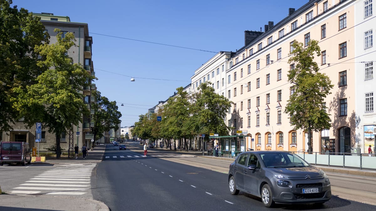 Auto, jalkakäytävä, suojateitä ja ratikkapysäkki Mannerheimintiellä  Linnankoskenkadun risteyksessä.
