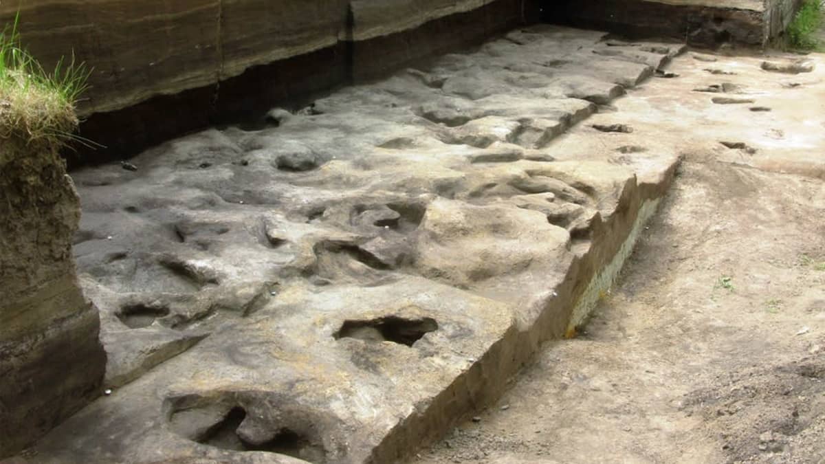 Kivettyneitä jalanjälkiä arkeologisen kaivauksen kuopassa. 