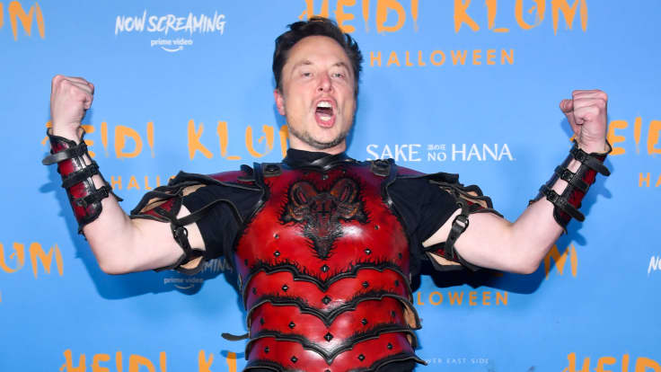 Naamiaisasuun pukeutunut Elon Musk näyttää hauiksiaan.