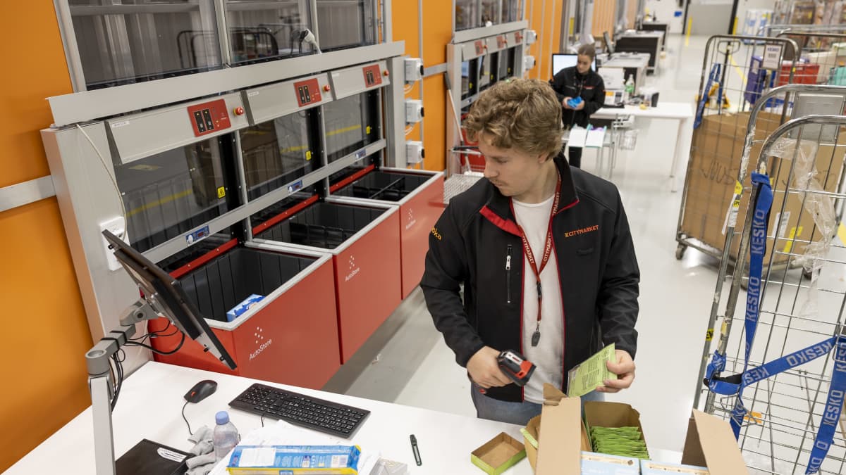  Verkkokaupan keräilijä Valtteri Peltonen lukee varastolaatikoihin siirrettävien tuotteiden viivakoodeja.
