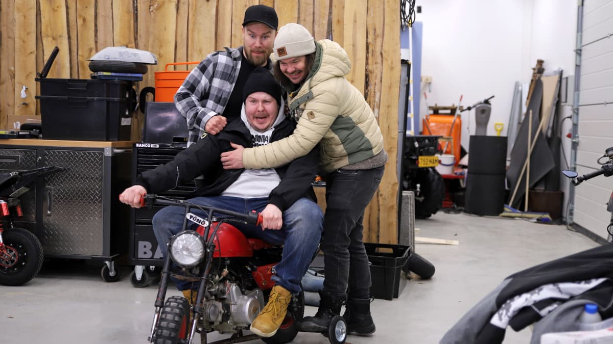 Biisonimafian Janne Kaperi, Kai Rinkinen ja Tuomas Rinkinen tasapainoilevat apupyörillä varustetun mopon päällä.