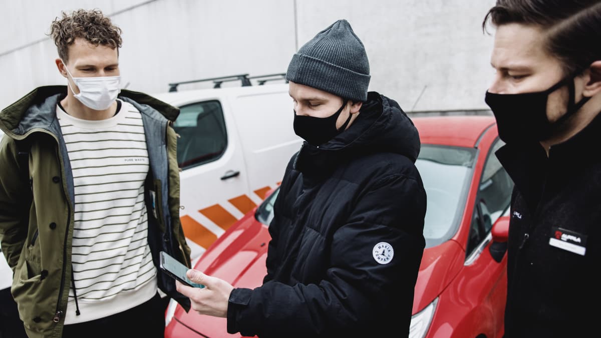 Gomoren edustaja Boris Perkiö (vas.) ja mekaanikko Jani Kivinen (oik.) seuraavat, kuinka Huotilaiselta sujuu auton etähallinta puhelinsovelluksella. 