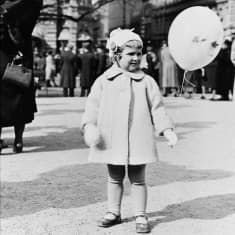 En finklädd flicka med en ballong i handen på Esplanaden i Helsingfors är 1939.