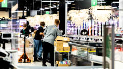 Kaupan työntekijät täyttävät pakastealtaita tuotteilla.