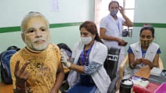 Terveydenhoitaja antaa koronarokottetta intialaiselle henkilölle.