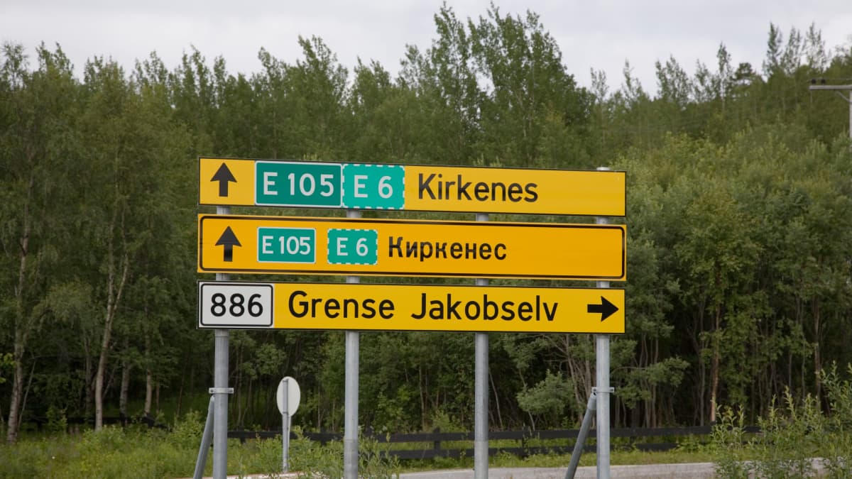 En gul vägskylt med Kirkenes i latinska och kyrilliska bokstäver.