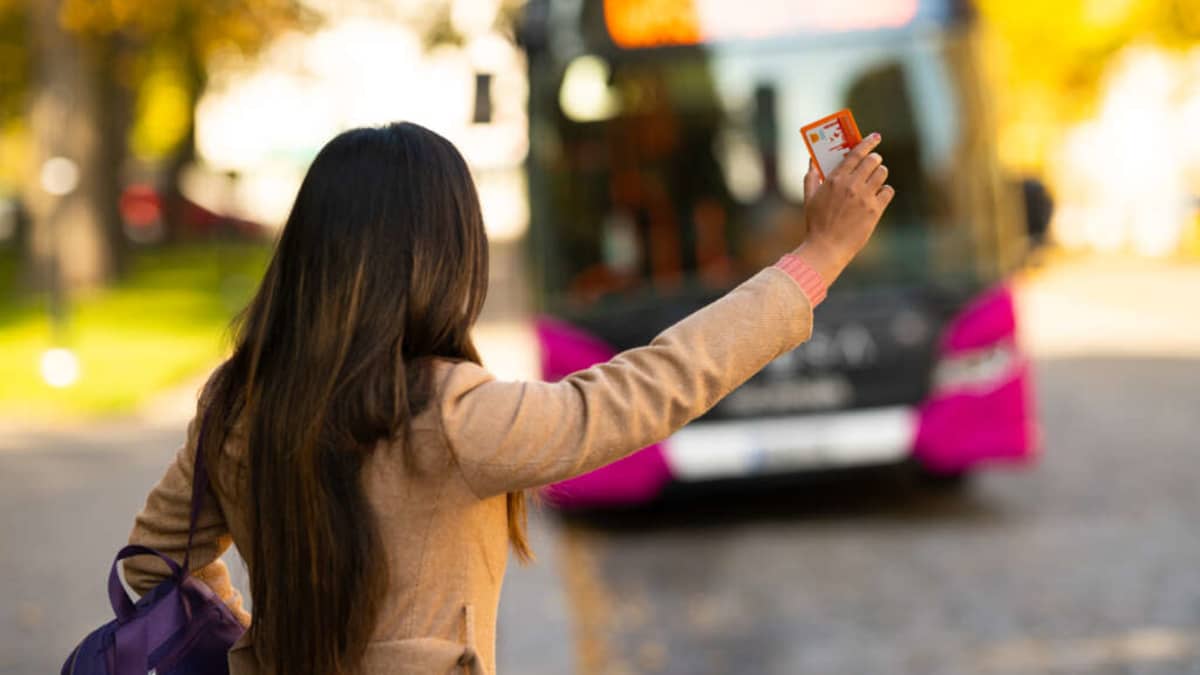 Nuori nainen pysäyttää linja-auton.