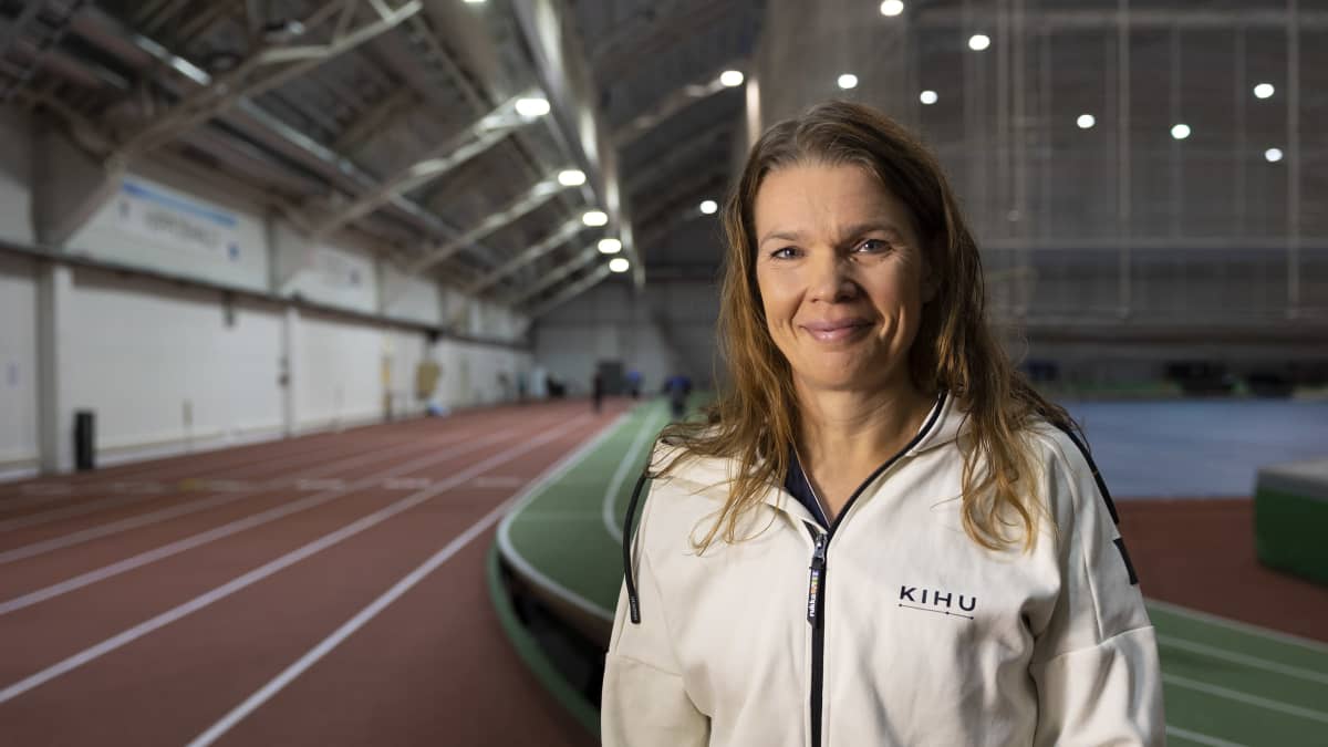 Urheilulääkäri Maarit Valtonen seisoo Jyväskylän Hipposhallin juoksuratojen välissä. 
