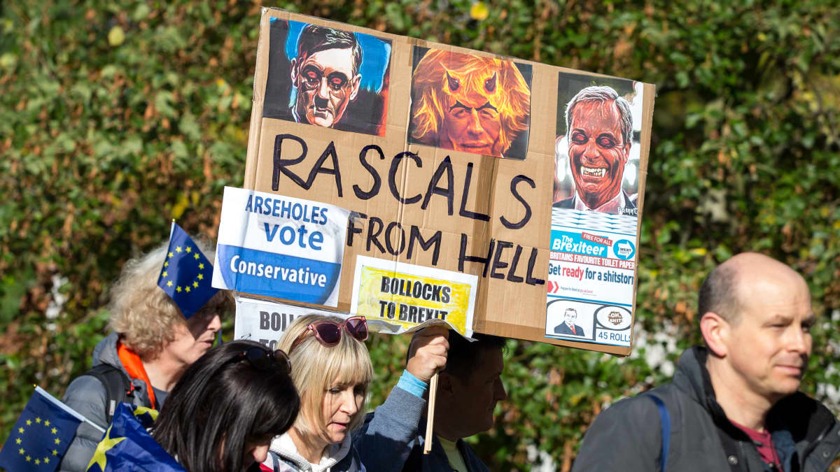 Mielenosoittajat kantavat Boris Johnsonia, Nigel Faragea ja Jacob Rees-Moggia pilkkaavaa kylttiä.