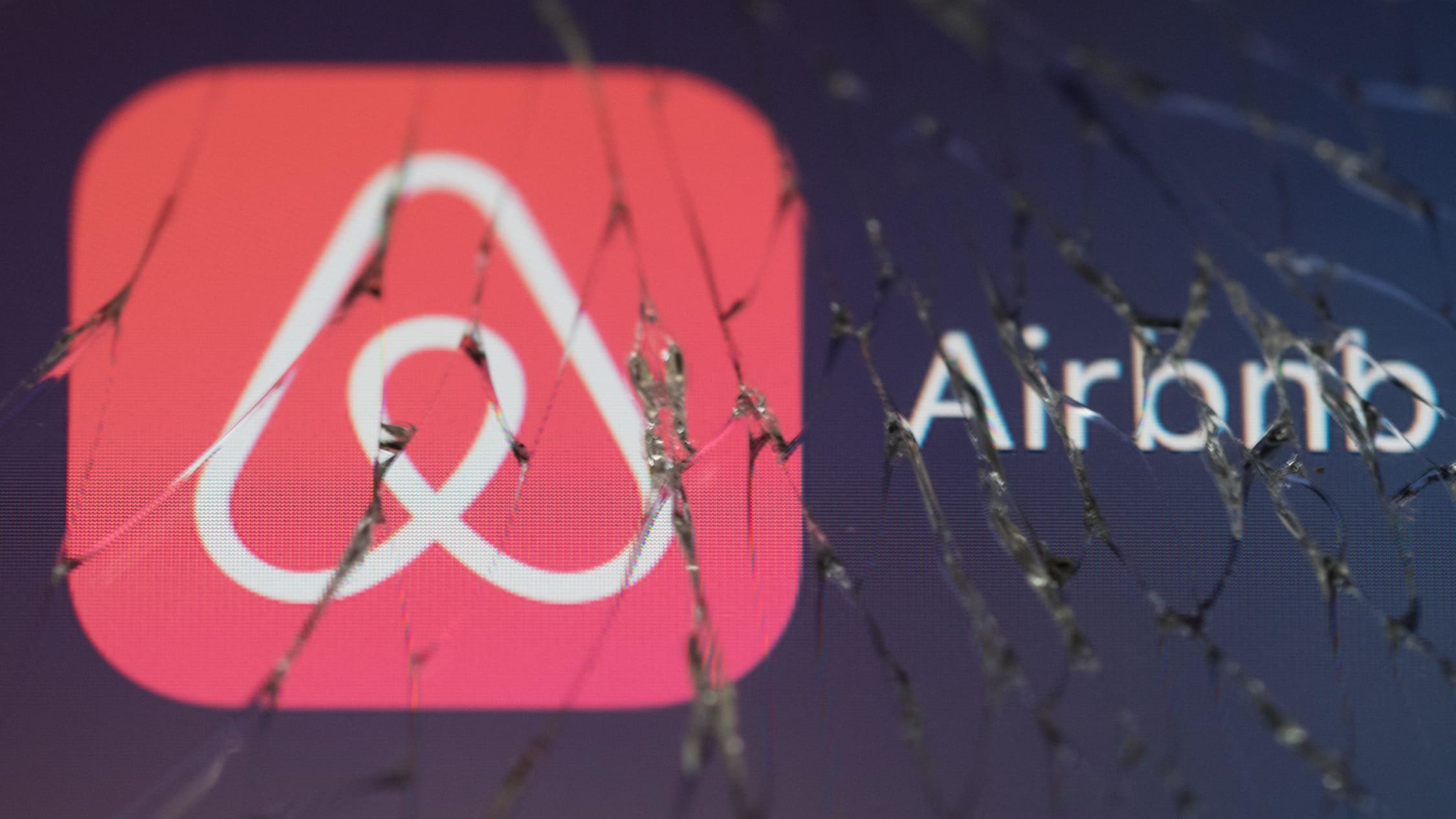 Airbnb logo rikkinäisen puhelimen näytön ruudussa.