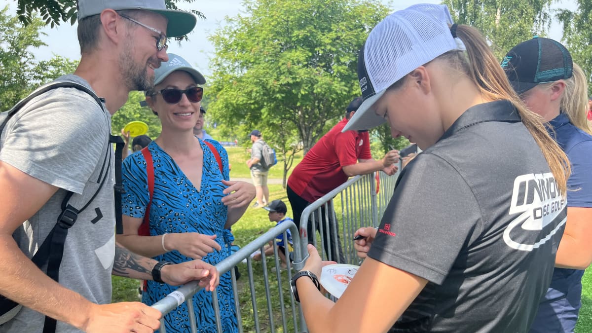 Paige Pierce signs fans discs after finishing her round on Friday. She has previously won the event in 2013 and 2019.