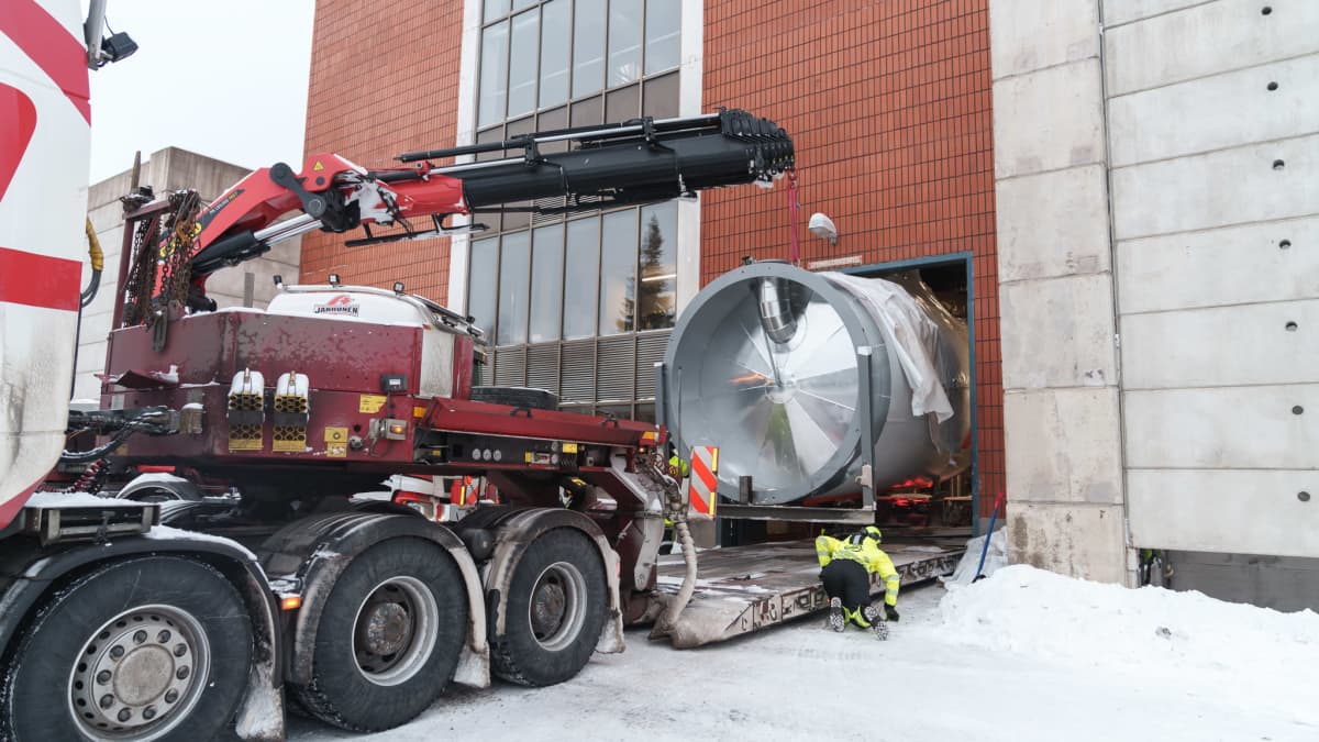 Tampereen sähkölaitoksen uutta, yli 7 metriä korkeaa sähkökattilaa viedään sisään voimalaitokseen seinään tehdystä reiästä.