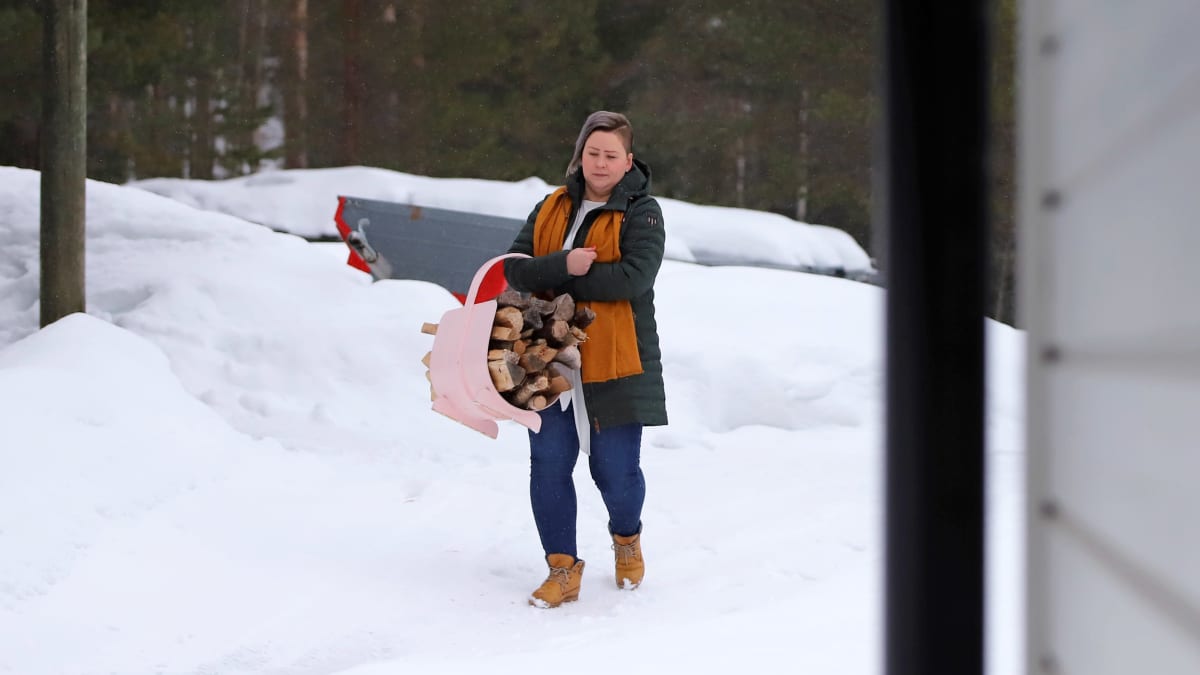 Juvalainen Anna-Mari Hangas-Tuovinen hakee polttopuita etätyöpäivänsä ohessa.