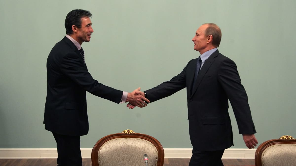 Naton pääsihteeri Anders Fogh Rasmussen ja Venäjän tuolloinen pääministeri Vladimir Putin ojentavat käsiään kätelläkseen joulukuussa 2009.