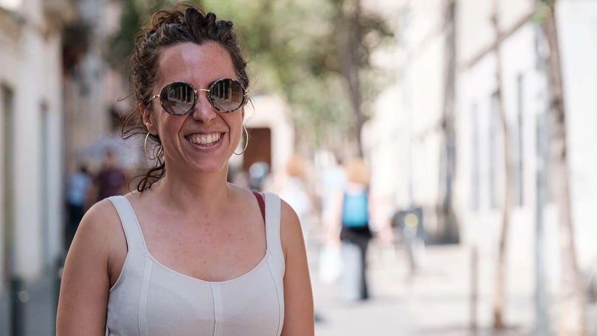 Kuvaa Barcelonan kaduilta. Nainen katsoo kameraan ja hymyilee. 