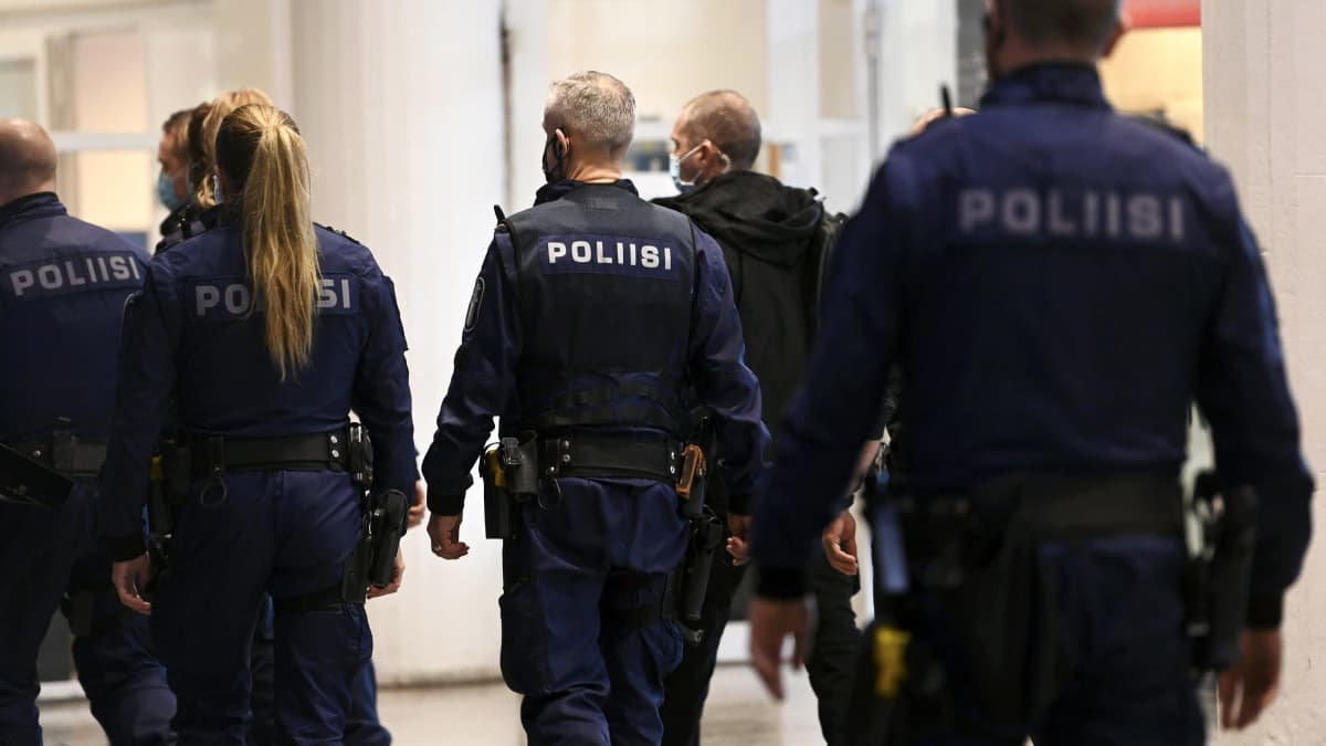 Poliiseja menossa turvasaliin jossa käsiteltiin katujengiläisten suunnittelemaa joukotappelua, Helsingin käräjäoikeudessa.