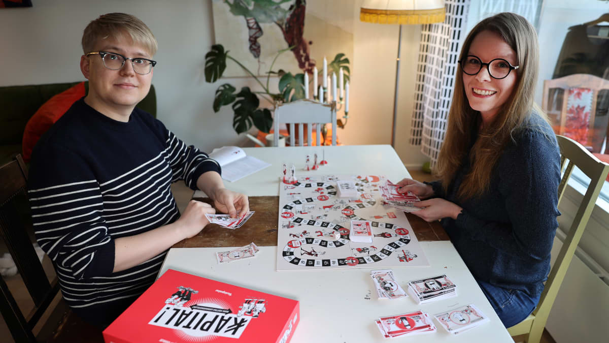 akatemiantutkija Hanna Kuusela ja kustannustoimittaja Tuukka Tuomasjukka pelaavat Kapital-lautapeliä.