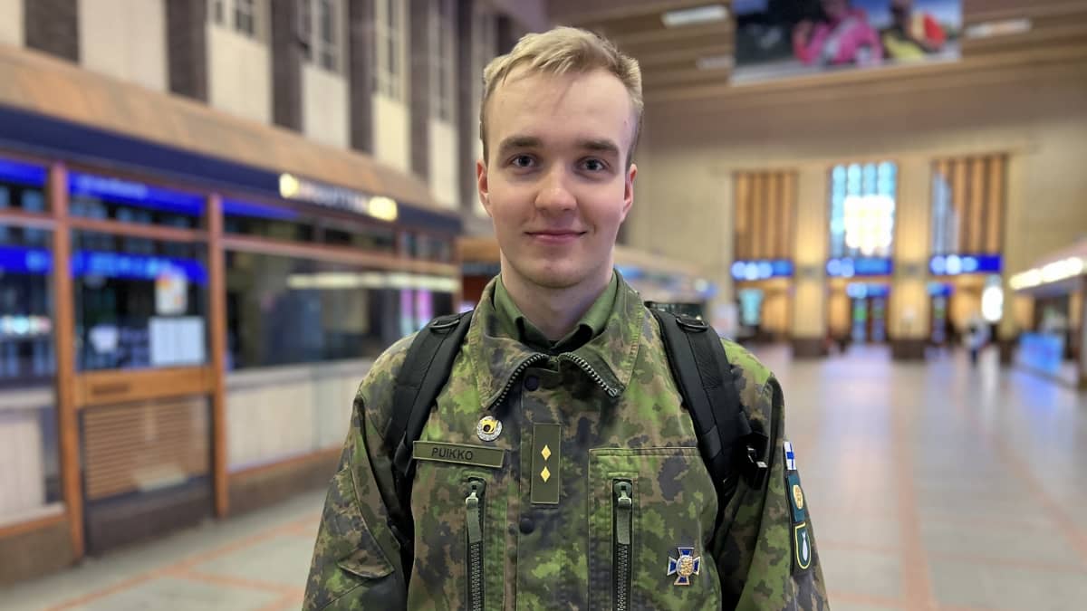 Armeijapukuinen mies seisoo Helsingin päärautatieasemalla.