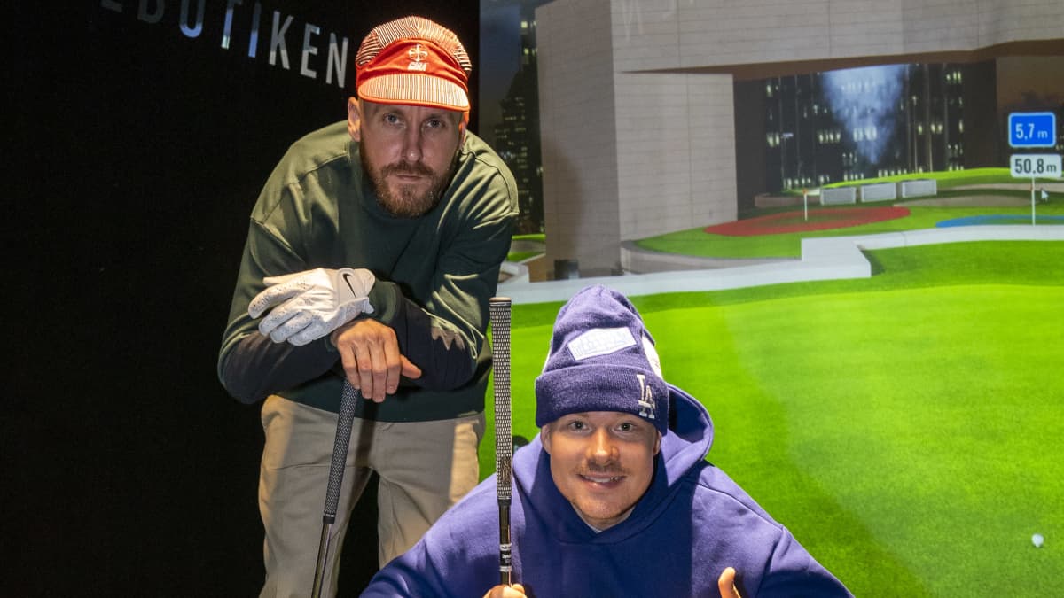 Rap-duo JVG:n Jare Joakim Brand ja Ville-Petteri Galle poseeraavat Salmisaari Golfin Golfsimulaattorissa.