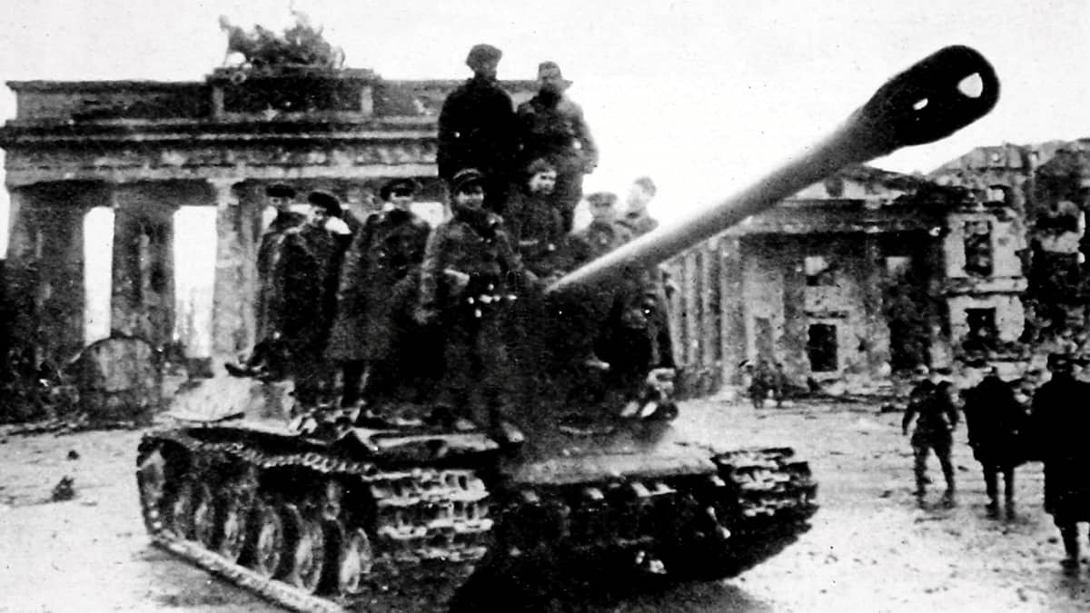 Neuvostojoukkojen panssarivaunu ajaa Berliinissä. Taustalla näkyy Brandenburgin portti. Vaunun päällä on sotilaita.