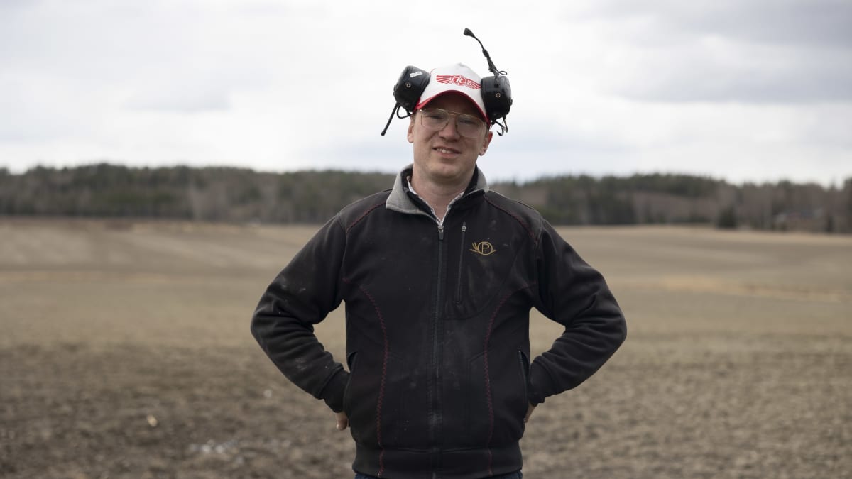 Erik Perklén Postiksen tilalla Siuntiossa poseeraa kameralle pellon laidalla.