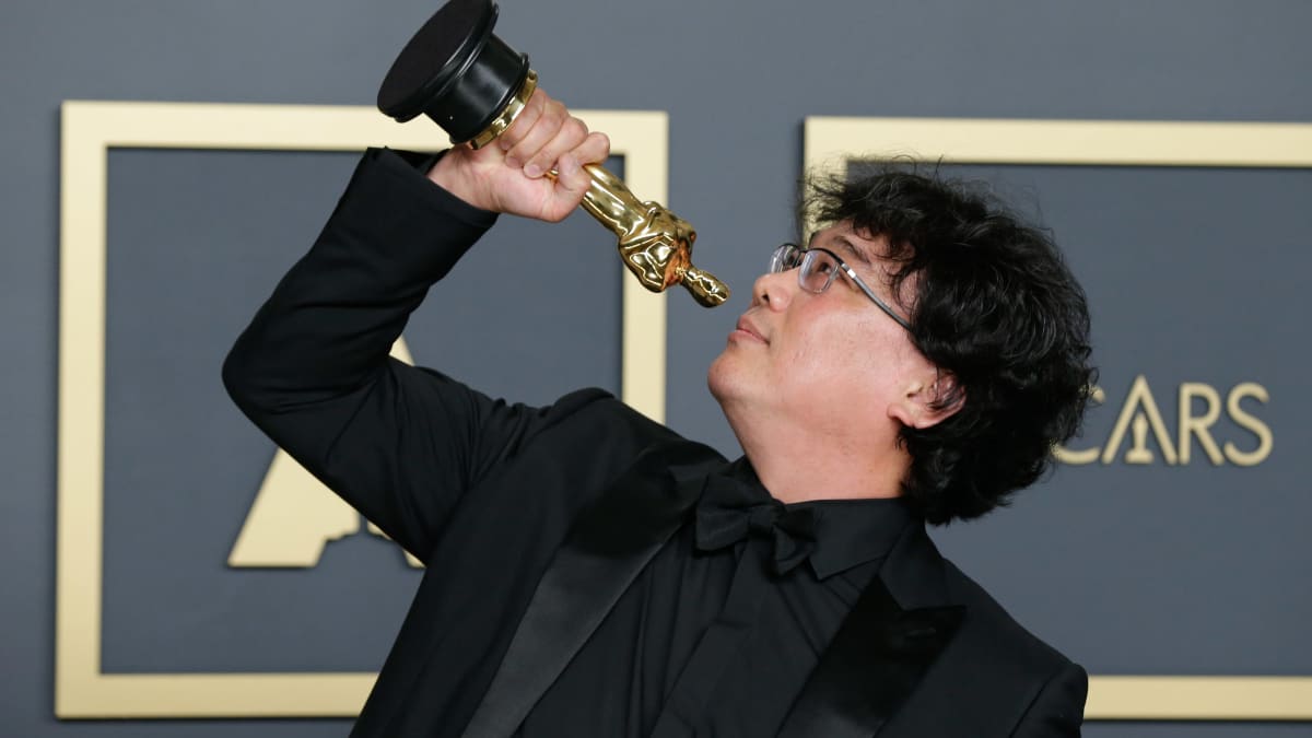 Bong Joon-ho håller i en Oscarsstatyett.