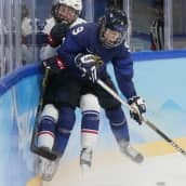Suomen Nelli Laitinen pysäyttää USA:n Grace Zumwinklen Pekingin olympialaisissa. Ensi kaudeksi taklaaminen sallitaan Ruotsin naisten liigassa ja 1. divisioonassa.