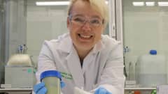 Professori ja tekniikan tohtori Ulla Lassi laboratoriossa kädessään kumihanskat.