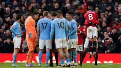 Jalkapallojoukkue Manchester Cityn pelaajat piirittivät erotuomarin.