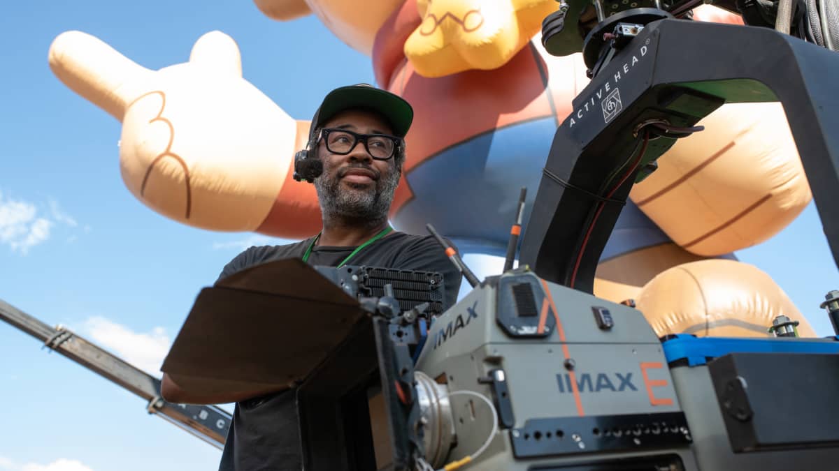 Ohjaaja Jordan Peele IMAX-kameran takana, taustalla iso ihmishahmon muotoinen ilmapallo.