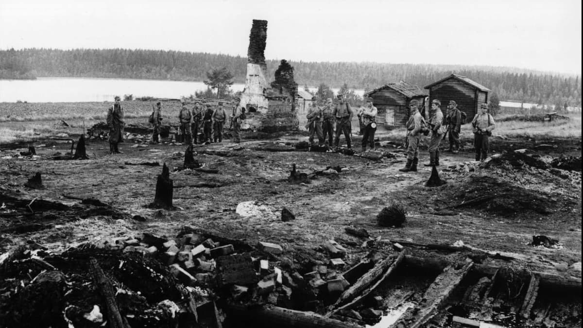 Suomalaisia sotilaita palaneen raunion juurella.