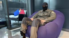 Naamioitunut suomalainen upseeri istuu nojatuolissa hotellin aulassa Kiovassa.