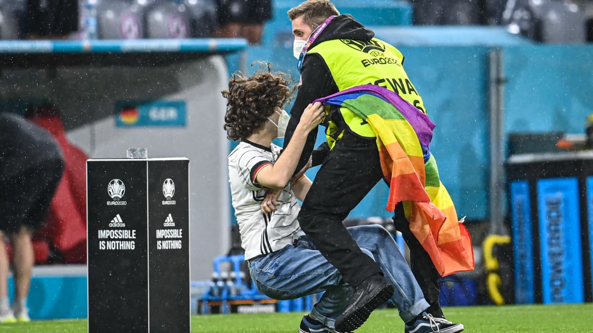 Fani sateenkaarilipun kanssa stadionilla ennen Saksan ja Unkarin kamppailua.