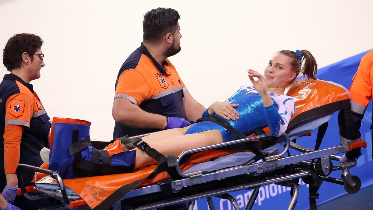 Skadade gymnasten Rosanna Ojala bärs ut på bår.