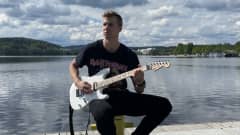 Ilari Manninen soittamassa kitaraa kesäpäivänä.