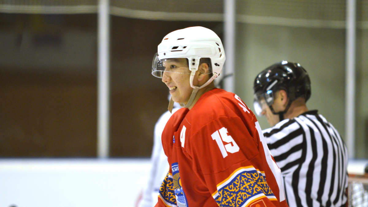 Kirgisian jääkiekkomaajoukkueen tehopelaaja Islambek Abdyraev hymyilee MM-kisoissa.