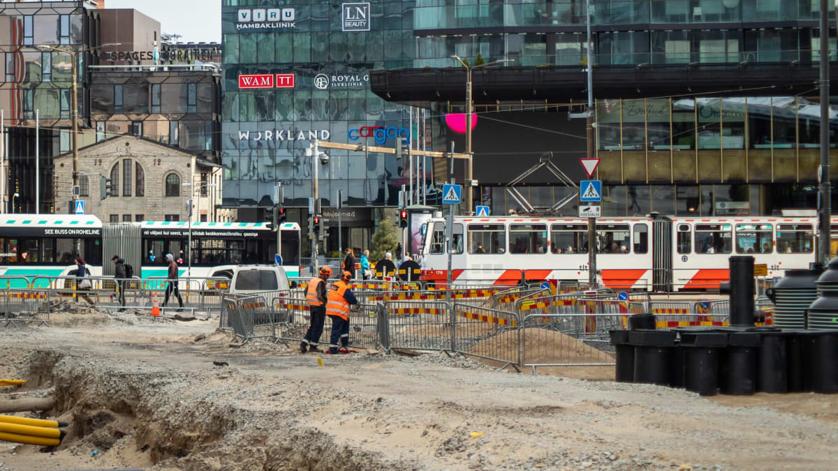 Iso katutyömaa jonka taustalla linja-autoja ja raitiovaunuja Tallinnassa.