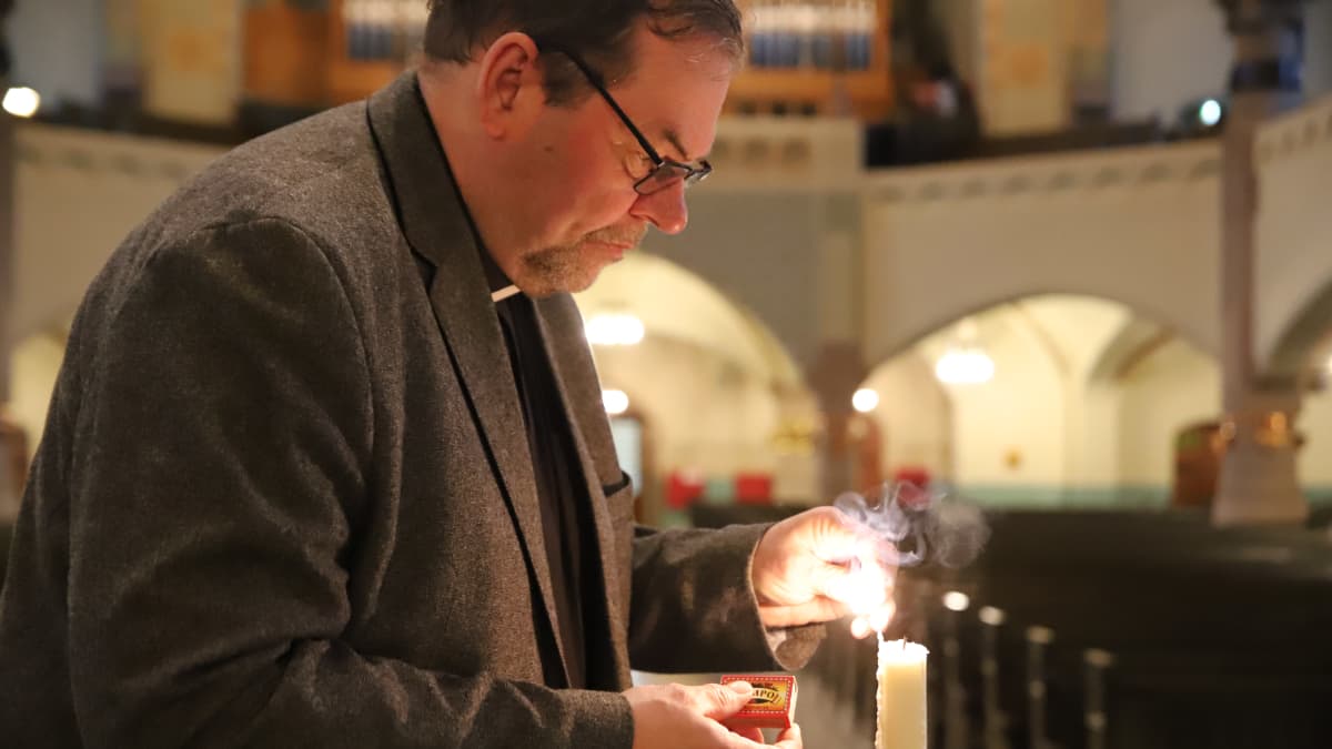 pappi sytyttää kynttilää