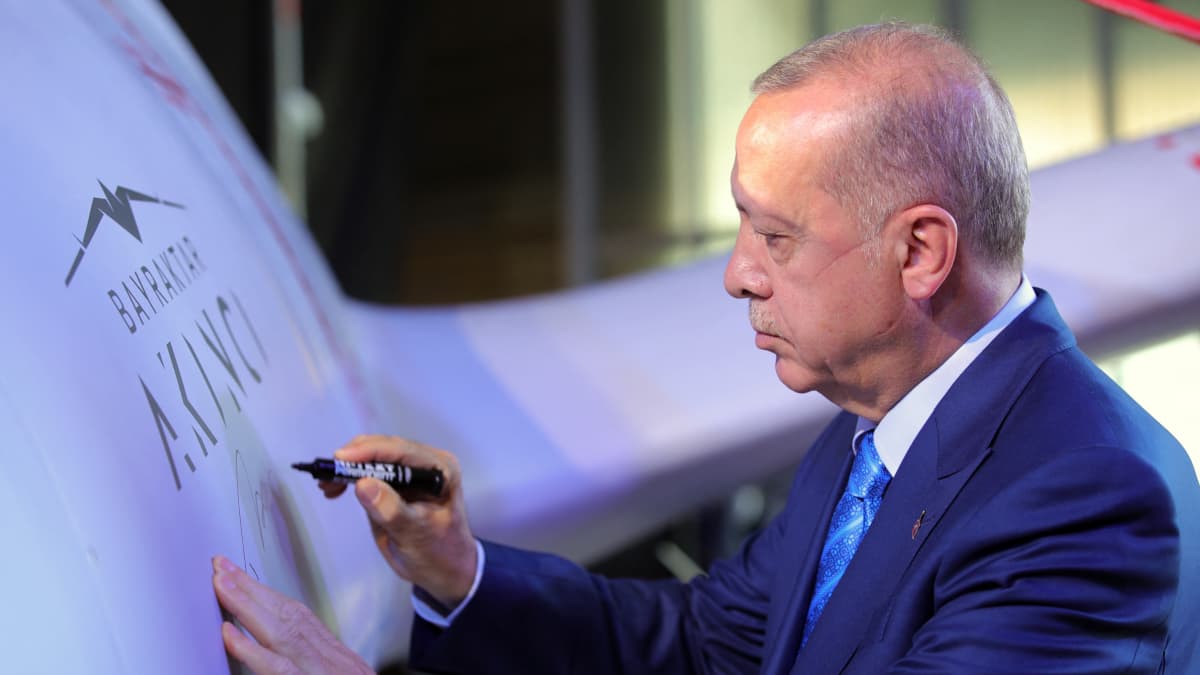 Turkin presidentti Recep Tayyip Erdogan kirjoittaa nimensä turkkilaisen Akinci Dronen kylkeen elokussa 2021.