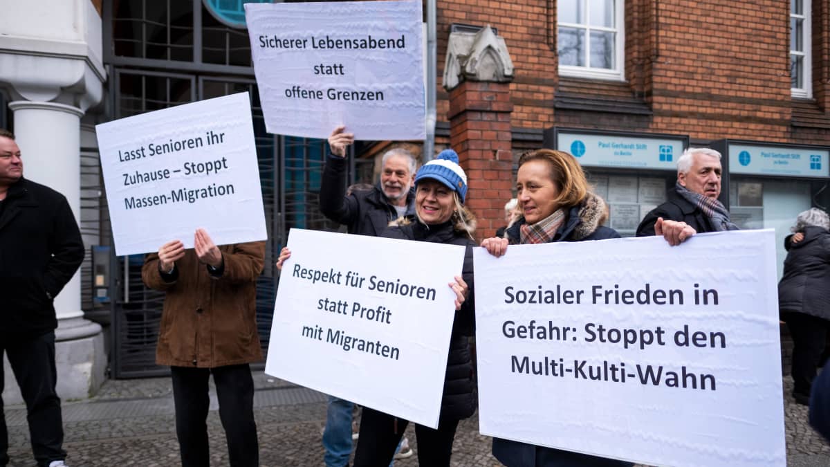 Ihmiset osoittavat mieltä kylttien kanssa porttikongin edustalla. Kuvassa muun muassa Beatrix von Storch (AfD).