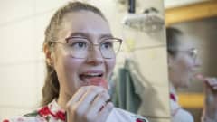Jenna Tirkkonen ottaa oikomiskojetta pois suustaan.
