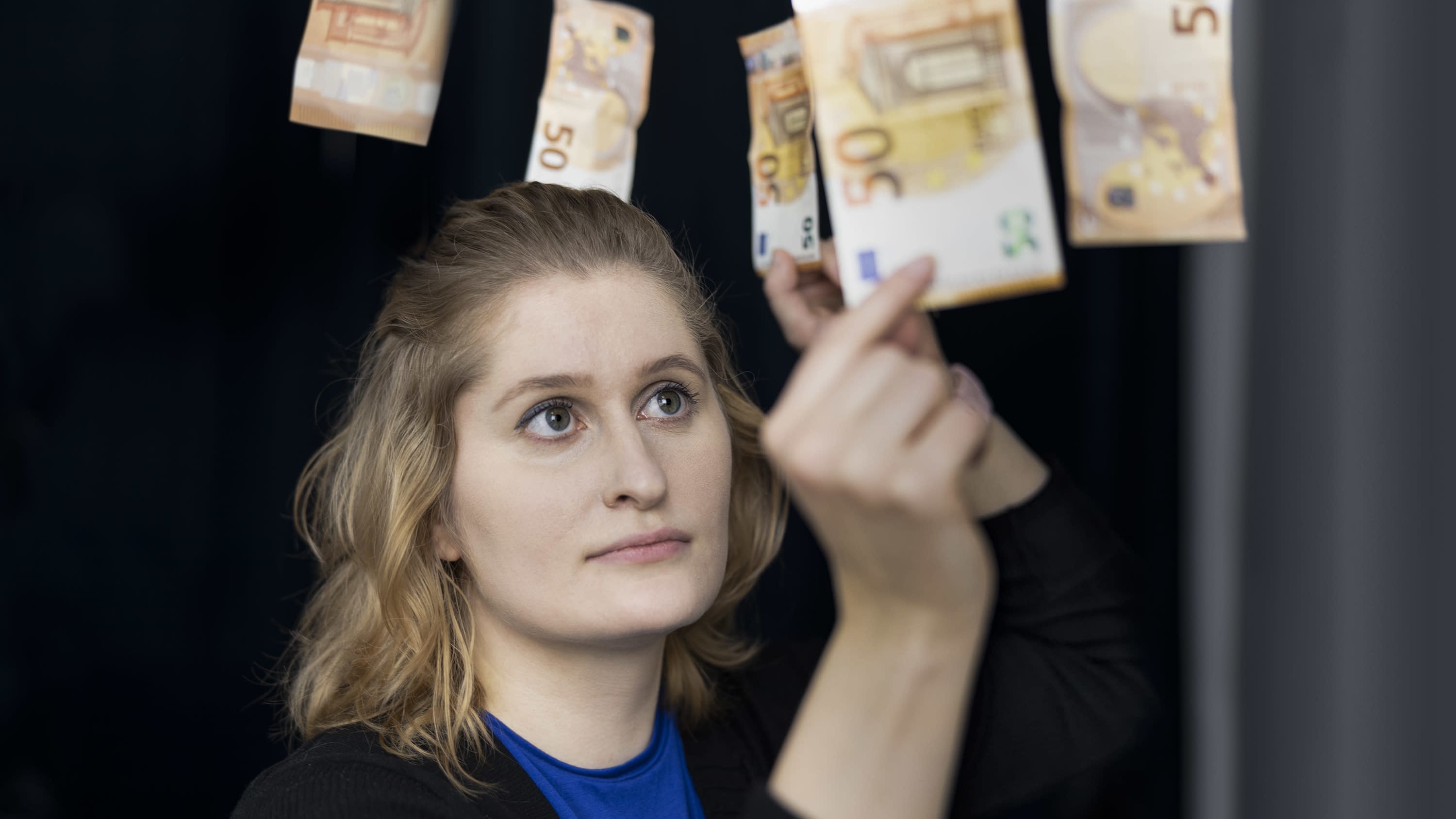 Liisa Salonen poimii viidenkymmenen euron seteteleitä ilmasta.