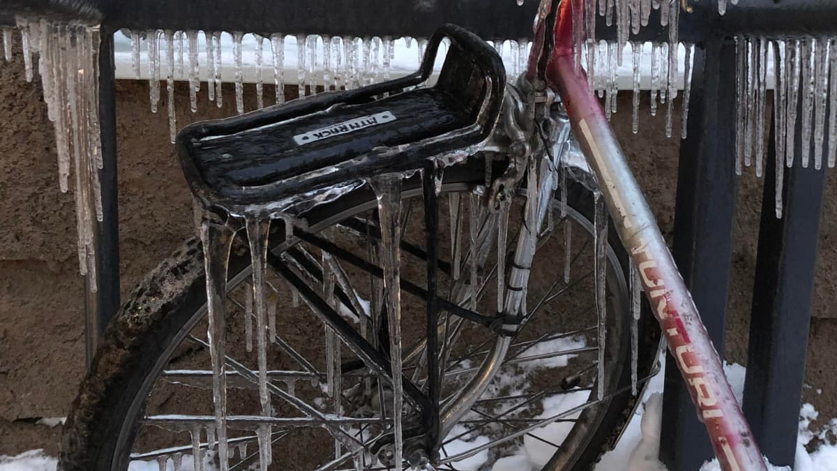 Asmon pyörä polkupyöräparkissa on talvella jääpuikkojen peitossa 