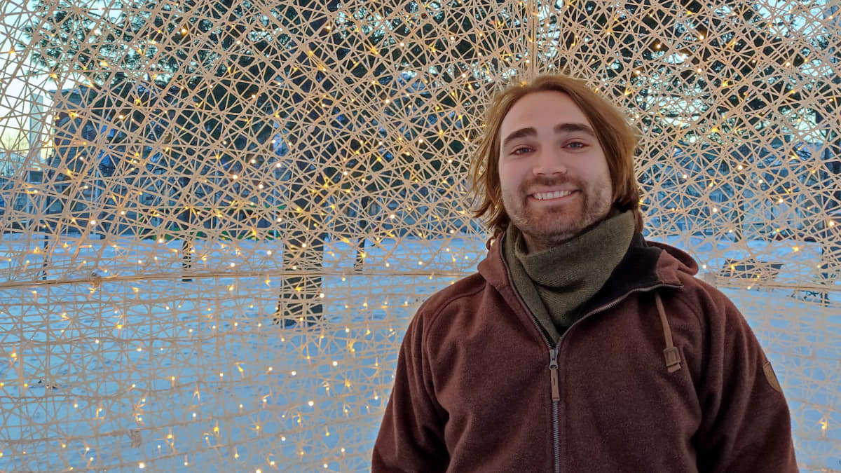 Teemu Hartman seisoo jouluvalopallon sisässä lumisessa maisemassa.