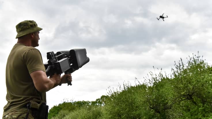 Ukrainalaissotilas testaa droonien alas ampumiseen suunniteltua asetta Kiovassa.