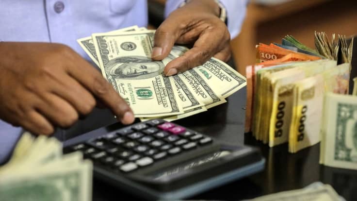 Srilankalainen rahanvaihtaja laski rahoja maaliskuussa 2022.