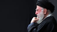 Iranin johtaja Ali Kahmenei istuu sivuttaiskuvassa hieroen partaansa.